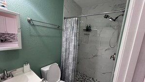 Kylpyhuone, jossa on wc, pesuallas ja suihku.