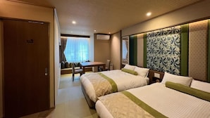 Habitación de hotel con dos camas, un escritorio y una silla.