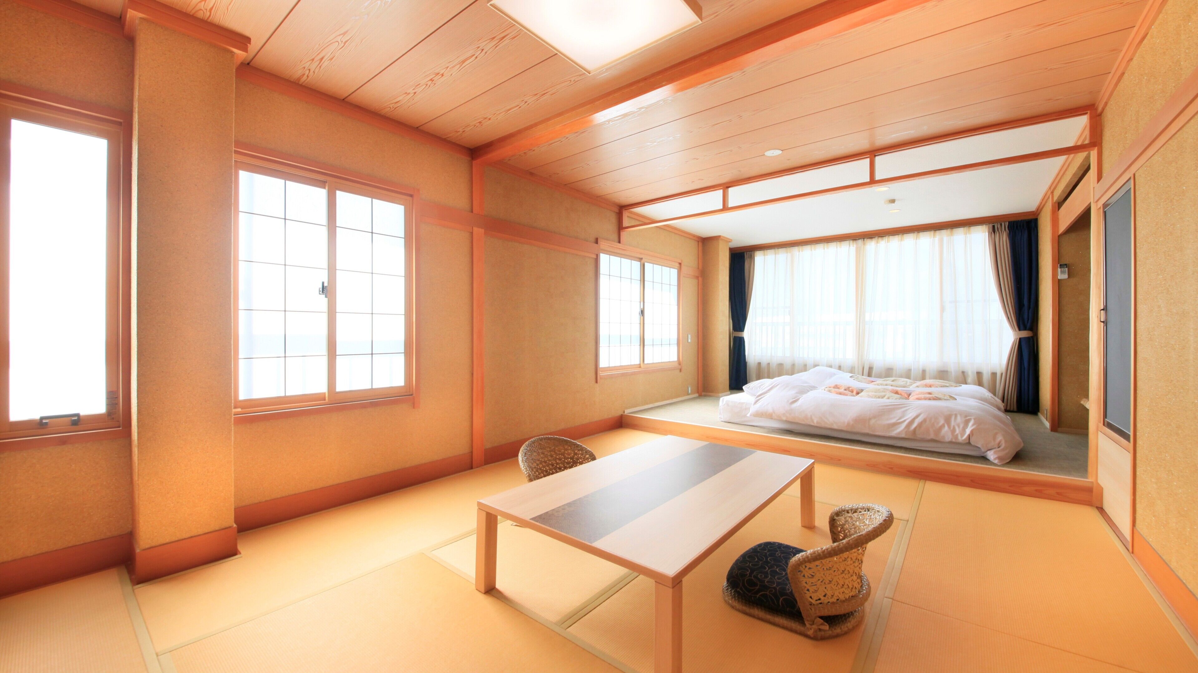 A traditional Japanese room with tatami flooring, a low table, a bed with futon, and large windows.