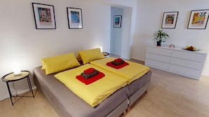 A bedroom with two beds, a dresser, and artwork on the walls. - Apartment Konstanz - Urban living for fitters, business travelers and holidaymakers (Konstant)