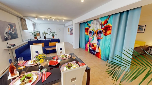 A dining area with a black table set for four, surrounded by blue sofas. - Apartment Konstanz - Urban living for fitters, business travelers and holidaymakers (Konstant)