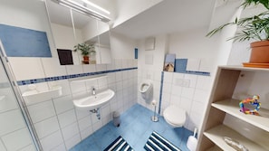 A bathroom with a sink, toilet, urinal, and a mirror. - Apartment Konstanz - Urban living for fitters, business travelers and holidaymakers (Konstant)