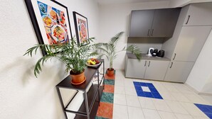 A modern kitchen with grey cabinets, a black countertop, and a tiled floor with a blue and orange pattern. - Apartment Konstanz - Urban living for fitters, business travelers and holidaymakers (Konstant)