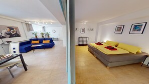 A modern living room with a blue sofa, a small table, and a grey couch with yellow pillows. - Apartment Konstanz - Urban living for fitters, business travelers and holidaymakers (Konstant)