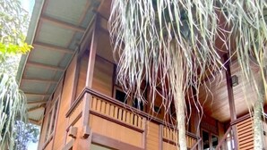 A two-story wooden house with a balcony and a staircase. - Ratu Roso Resort (Ulesari)