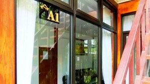 A room with a bed, a wooden staircase, and a sign with the letter 'A'. - Ratu Roso Resort (Ulesari)