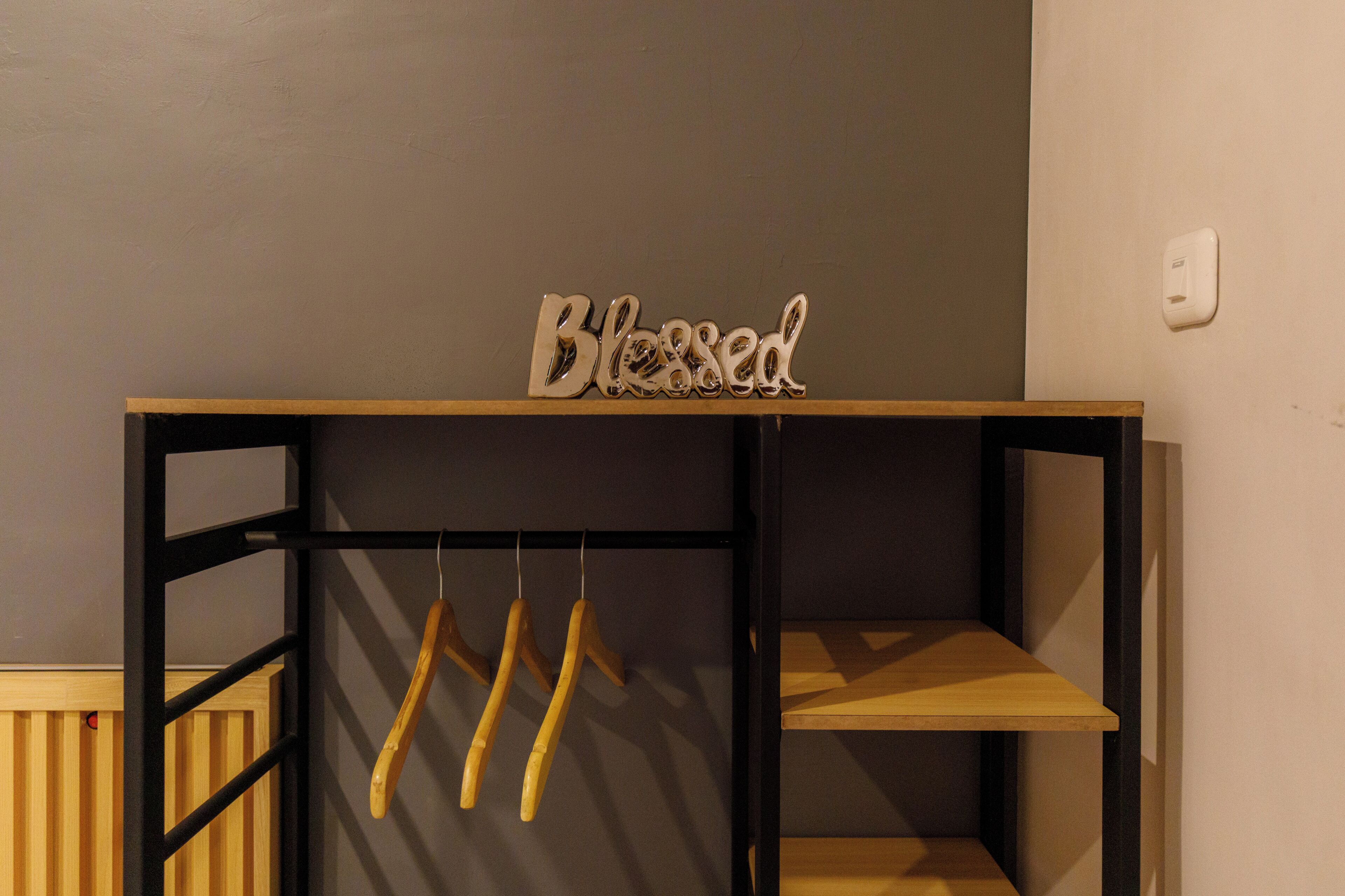 A wooden shelf unit with a sign that reads 'Blessed' on top.