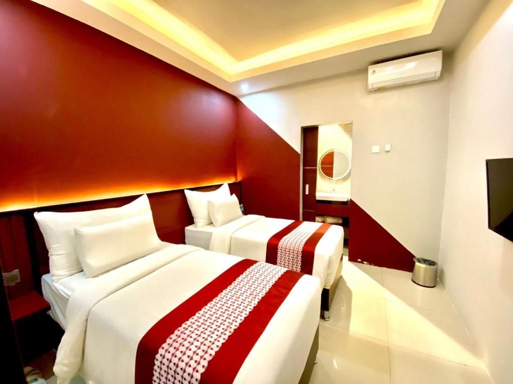 A hotel room with two beds, a large mirror, and a modern design.