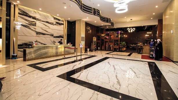 A spacious lobby with a marble floor, a reception desk, and a staircase leading to an upper level. - Gayo Petro Hotel (Takengon)