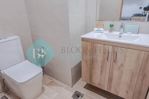 Un bany amb vàter, un lavabo i un mirall.