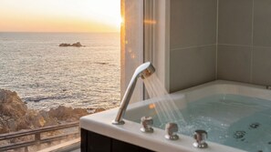 A bathtub with a view of the sea and rocks. - Gyeongju Sea View Pool Villa (Gyeongju)