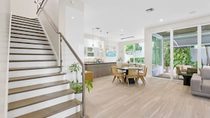 A modern interior with a staircase, dining area, and large windows. - Beachside Bliss | Luxury Villa with Sauna & Pool (Fort Lauderdale)