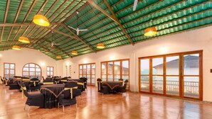 A spacious hall with a high ceiling, large windows, and tables set up for an event. - The BaghVilla Pench FicusrootsExperience (Kurai)