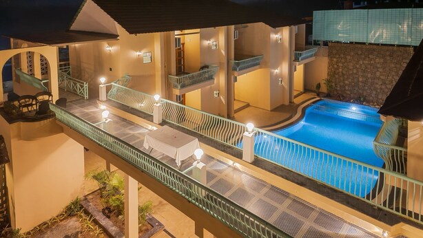 A multi-level outdoor swimming pool area with a covered seating area and a staircase. - The BaghVilla Pench FicusrootsExperience (Kurai)
