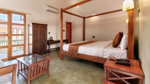 A room with a four-poster bed, a wooden desk with a chair, a glass-top table, and a small bedside table with a lamp. - The BaghVilla Pench FicusrootsExperience (Kurai)