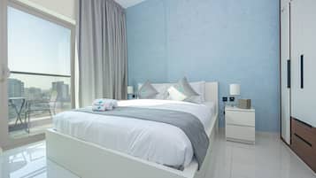 Een moderne slaapkamer met een groot bed, een nachtkastje, een dressoir en uitzicht op de stad door een groot raam.