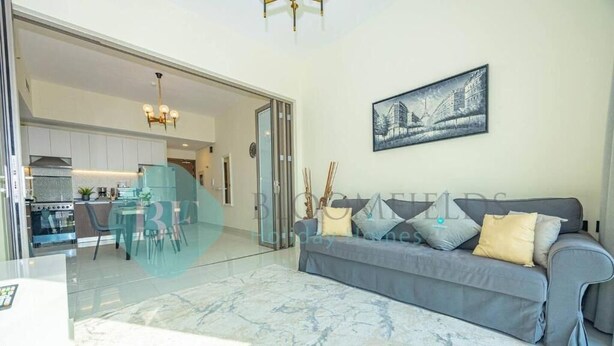 A modern living room with a grey sofa, a marble floor, and a cityscape painting on the wall. - Bloomfields Modern 1Bedroom In Wavez (Dubai)
