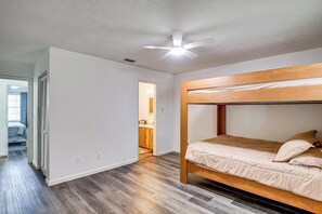 A bedroom with a bunk bed, a ceiling fan, and hardwood flooring. - Sun, Sand & Poolside Relaxation! Ormond Beach Unit (Ormond Beach)
