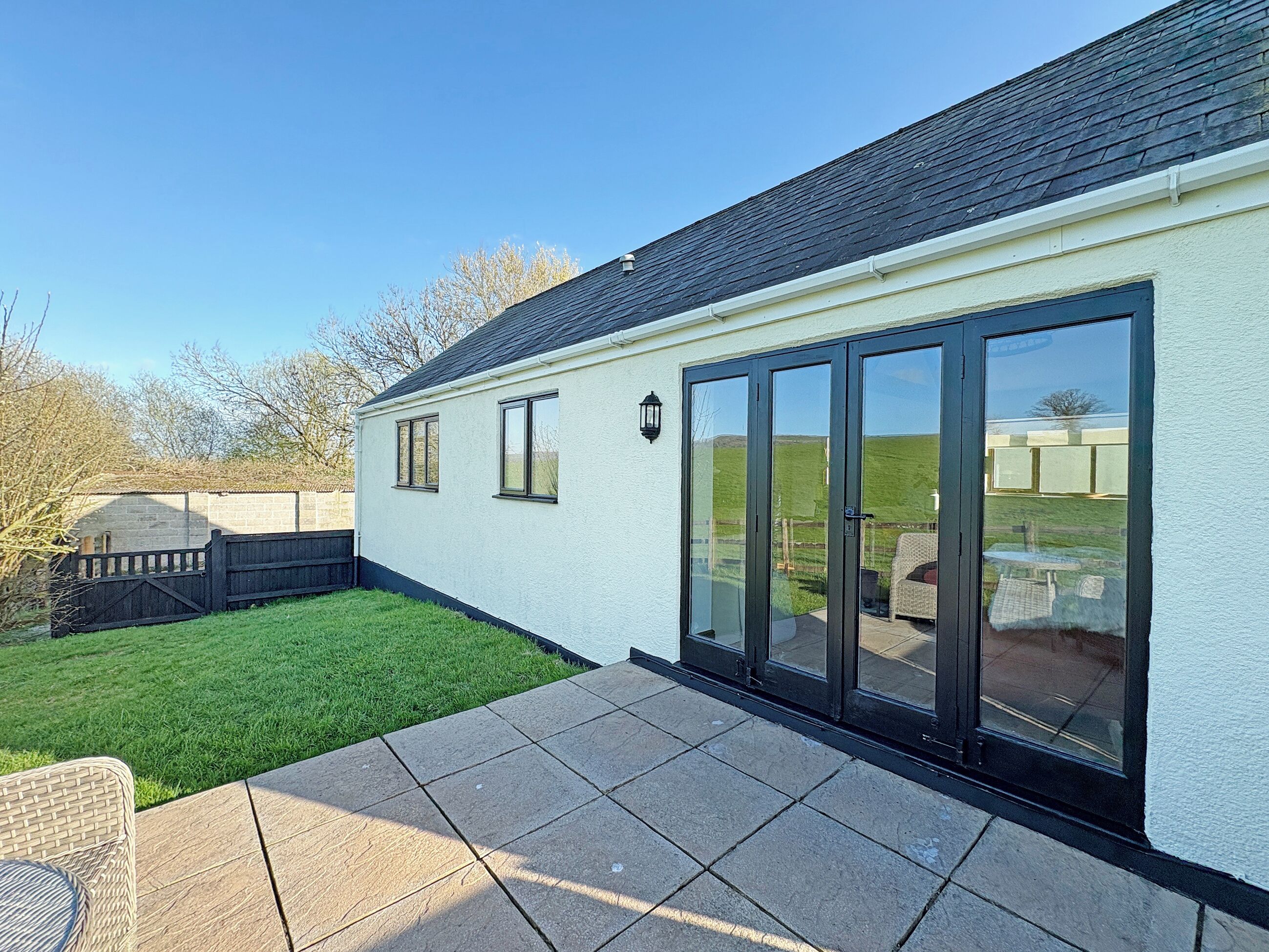 A house with a patio, a lawn, and a view of the countryside.