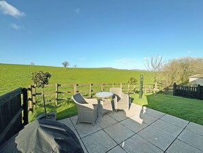 A patio with outdoor furniture and a view of a green field. - 1 bedroom accommodation in Bridport (Bridport)