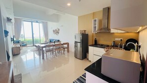 A modern kitchen with a dining area, a refrigerator, and a stove. - C-5 Oceanfront Condos  (Galle)
