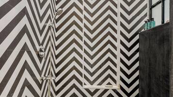 A modern bathroom with a black and white chevron tile pattern on the walls and floor.