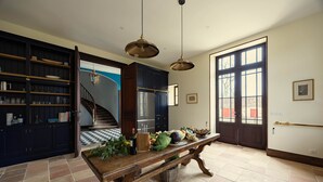 A kitchen with a wooden table, dark cabinets, and a large window. - Wild Elegance: A 120-Acre Forest & Château (Mouleydier)