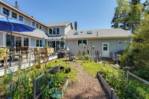 Een woonhuis met een achtertuin, tuinmeubilair en een overdekt terras.