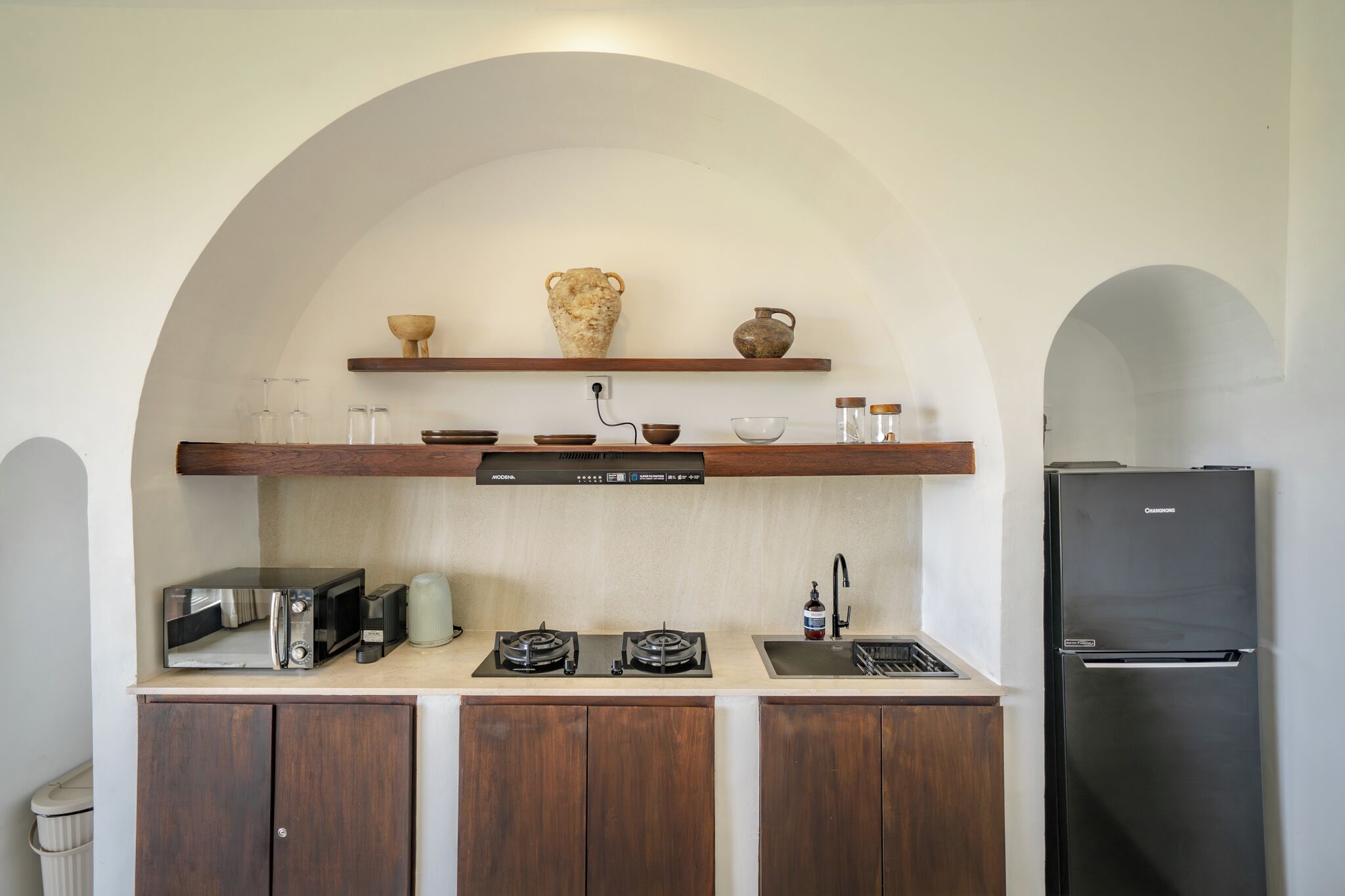 A kitchen with a microwave, toaster, stove, sink, and refrigerator.