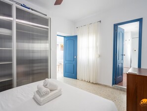 A hotel room with a bed, a wardrobe, a desk, and a bathroom door. - Apartamento Encanto Gaditano con Terraza by C diz (Cádiz)