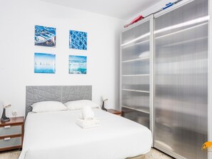 A hotel room with a bed, a wardrobe, and four framed pictures on the wall. - Apartamento Encanto Gaditano con Terraza by C diz (Cádiz)