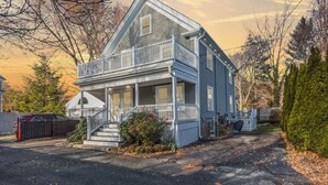 Una casa a due piani con un balcone, un portico e una strada privata.