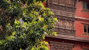 Un edificio de varios pisos con detalles arquitectónicos tradicionales, como balcones ornamentados y fachada de ladrillo rojo.