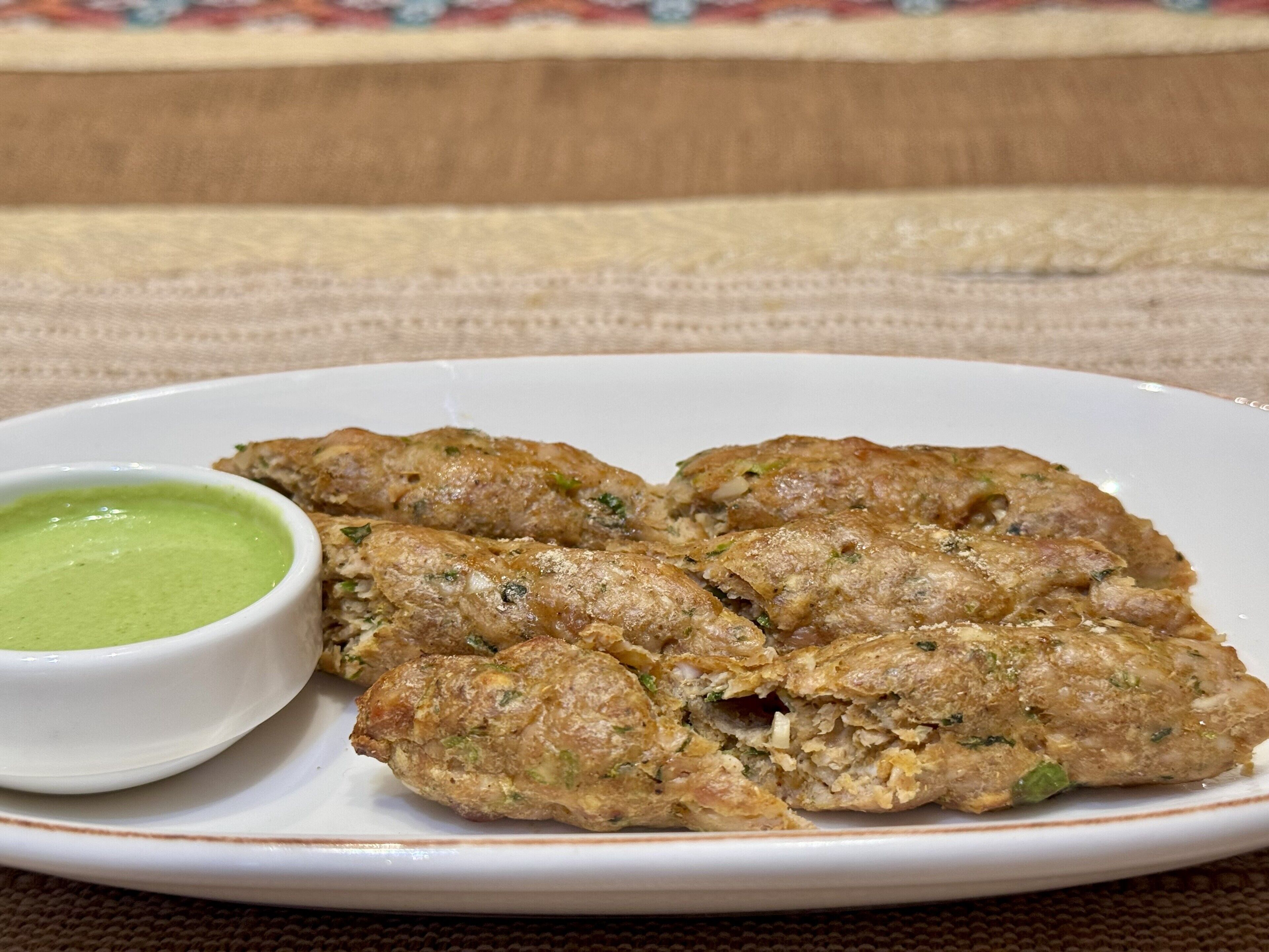 A plate of food with a green sauce on the side.