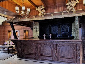 Un intérieur en bois agrémenté de sculptures décoratives, d’un lustre et d’une statue.
