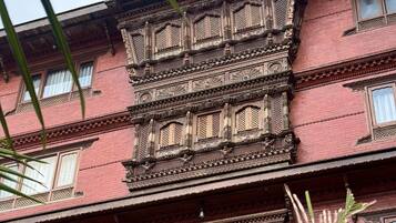 A multi-story building with intricate architectural details, including ornate balconies and patterned windows.