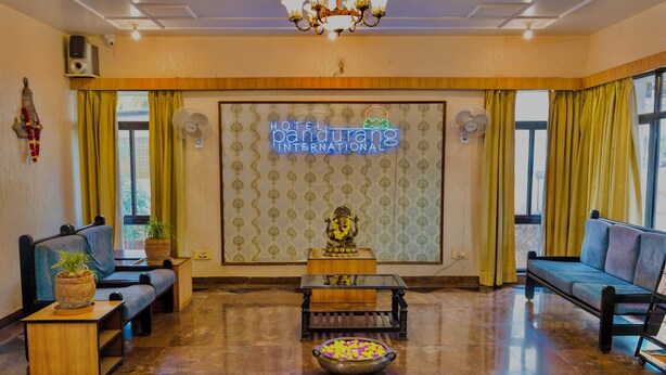 Un hall d’hôtel comprenant un comptoir d’accueil, un espace salon et une statue décorative.