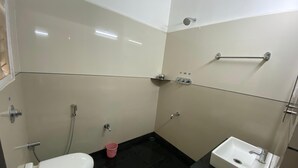 Une petite salle de bain avec des toilettes, un lavabo et une douche.