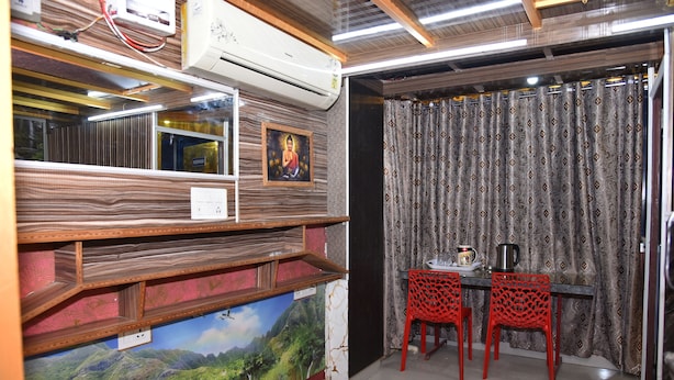 Una habitación con un mural de un paisaje montañoso, una mesa con sillas y un equipo de aire acondicionado.