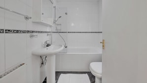 A bathroom with a white sink, a bathtub, and a toilet. - Hertford Flat 4 (London)