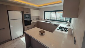 A modern kitchen with a built-in oven, microwave, and gas stove.