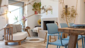 A cozy living room with a fireplace, a round coffee table, and a blue chair. - Exclusive, Modern Country House with Private Pool – Your Dream Holiday in Puglia (Puglia)