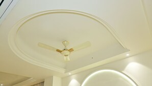 Un plafond doté d’un ventilateur de plafond, d’un éclairage encastré et de moulures décoratives.