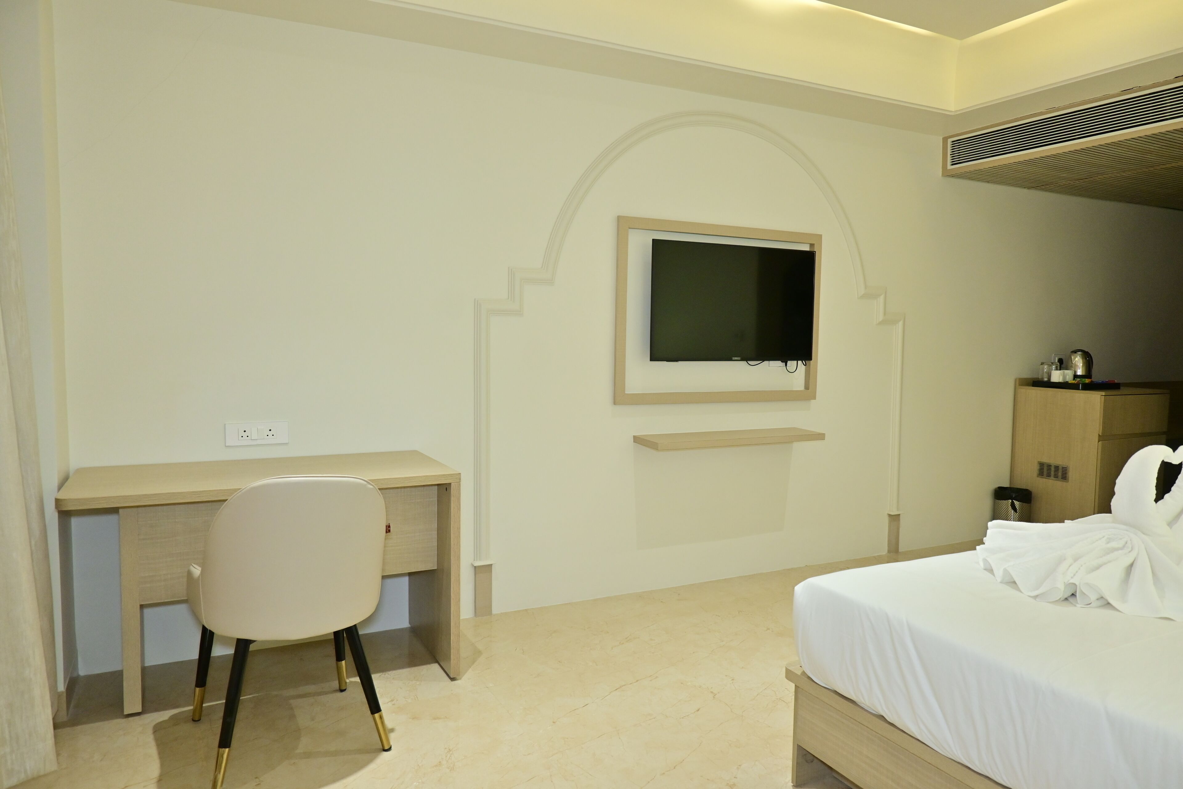 Une chambre d’hôtel équipée d’un lit, d’un bureau, d’une chaise, d’une télévision et d’une armoire.