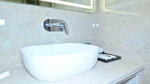 Une salle de bain avec un lavabo blanc, un miroir et un porte-serviettes.