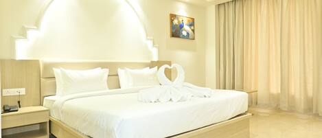 A hotel room with a large bed, a nightstand, a painting on the wall, and a window with curtains.