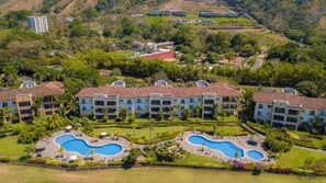 A resort with multiple buildings, a central swimming area, and lush greenery. - Del Mar 3C 3 bdr Ocean View in Los Suenos (Jacó)