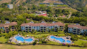 Een resort met meerdere gebouwen, een centraal zwembad en aangelegde tuinen.