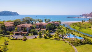 A resort with multiple buildings, a swimming pool, and a view of the ocean and beach. - Bay Residence 7C 3 bdr Ocean View in Los Suenos (Jacó)