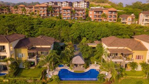 A resort with multiple buildings, a central swimming pool, and lush greenery. - Vista Bahia 1F 1 bdr Ocean View in Los Suenos (Jacó)